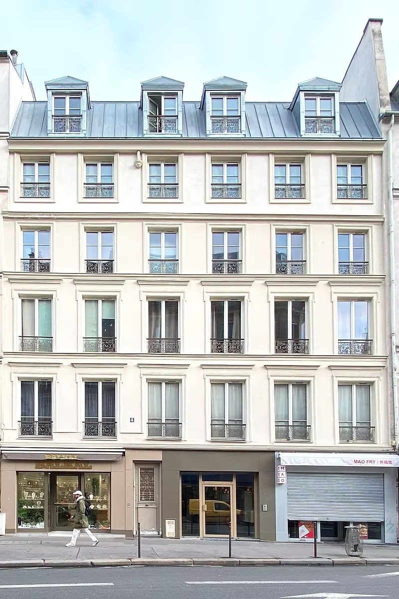 Façade rénovée après surélévation à Paris, avec ravalement, nouvelles menuiseries et lucarnes en toiture.